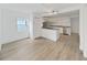 Open-concept living area adjacent to the kitchen with wood-look flooring at 1708 E Poinsettia Ave, Tampa, FL 33612