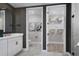 Well-designed bathroom featuring a stylish vanity, patterned wallpaper, and a convenient walk-in closet for optimal storage at 17390 Moonflower Dr # 102, Venice, FL 34293