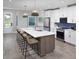 Bright kitchen with stainless steel appliances, marble countertops, large island with seating, and blue backsplash at 17390 Moonflower Dr # 102, Venice, FL 34293