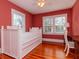 Small bedroom with white bed, wood floors, and coral walls at 207 28Th N Ave, St Petersburg, FL 33704