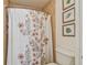 Clean bathroom with floral shower curtain and framed botanical prints at 2400 Feather Sound Dr # 515, Clearwater, FL 33762