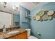 Bathroom with blue walls, granite countertop, and decorative wall art at 2400 Feather Sound Dr # 515, Clearwater, FL 33762