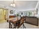 Dining area with wooden table, gray sofa, and view of trees at 2400 Feather Sound Dr # 515, Clearwater, FL 33762