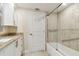 Bright bathroom featuring white cabinets, granite countertop, and a glass-enclosed tub/shower at 4 Belleview Blvd # 801, Belleair, FL 33756