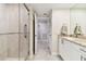 Clean bathroom features a glass enclosed shower, a single granite vanity, and tile flooring at 4 Belleview Blvd # 801, Belleair, FL 33756