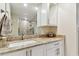 White bathroom vanity with granite countertop and a walk-in shower with tile surround and glass door at 4 Belleview Blvd # 801, Belleair, FL 33756