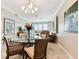 Dining area with a glass-top table, chandelier, and views of the living room and balcony at 4 Belleview Blvd # 801, Belleair, FL 33756
