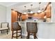 Modern kitchen with wood cabinetry, stainless steel appliances, and bar seating at 4 Belleview Blvd # 801, Belleair, FL 33756