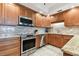 Kitchen boasts stainless steel appliances, wood cabinetry, and granite countertops at 4 Belleview Blvd # 801, Belleair, FL 33756