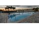 Inviting pool with waterfront views and palm trees at sunset at 4 Belleview Blvd # 801, Belleair, FL 33756