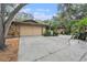 Two-car garage with a stone facade and a long driveway at 44 Pinewood Cir, Safety Harbor, FL 34695