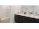 Dual vanity bathroom with dark wood cabinets and a shower at 5047 Captain Davis Dr, Wimauma, FL 33598