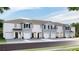 Row of townhomes with gray siding, white trim, and attached garages at 5047 Captain Davis Dr, Wimauma, FL 33598