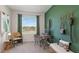 Stylish home office with green accent wall and natural light at 5047 Captain Davis Dr, Wimauma, FL 33598