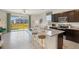 Modern kitchen with dark wood cabinets, stainless steel appliances, and an island with bar seating at 5047 Captain Davis Dr, Wimauma, FL 33598