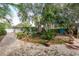 Landscaped backyard with brick pavers, tropical plants, and a view of the house at 628 Pine St, Tarpon Springs, FL 34689