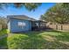 Spacious backyard featuring a screened porch, lush lawn, and wood fence at 6937 Exeter Park Pl, Apollo Beach, FL 33572