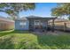 Spacious backyard with covered screened porch and lush green lawn at 6937 Exeter Park Pl, Apollo Beach, FL 33572