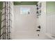 Clean bathroom with white tile, shower/tub combo, and black fixtures at 6937 Exeter Park Pl, Apollo Beach, FL 33572