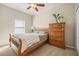 Sleigh bed, wooden dresser, ceiling fan, and carpeted floors in this bedroom at 6937 Exeter Park Pl, Apollo Beach, FL 33572