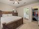 Primary bedroom showcasing wooden bedframe, attached bathroom, and walk-in closet at 6937 Exeter Park Pl, Apollo Beach, FL 33572