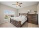 Bedroom featuring wooden bedframe, ceiling fan, window, and dresser at 6937 Exeter Park Pl, Apollo Beach, FL 33572
