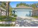 Front exterior of the house with blue siding, double garage, and palm tree at 6937 Exeter Park Pl, Apollo Beach, FL 33572