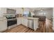 Modern kitchen with stainless steel appliances, white shaker cabinets, and wood-look flooring at 6937 Exeter Park Pl, Apollo Beach, FL 33572
