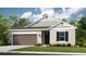 Charming single-story home with a brown garage door, black shutters, and a landscaped front yard at 708 Sky Shade Dr, Apollo Beach, FL 33572