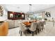 Open-concept living and dining area with a wood accent wall, fireplace, and sliding glass doors at 8750 Ivy Stark Blvd, Wesley Chapel, FL 33545