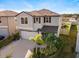 Aerial view of a two-story home with landscaped yard and driveway at 9334 Lemon Drop Loop, Sun City Center, FL 33573