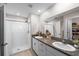 Bathroom featuring double sinks, granite countertops, walk-in shower, and walk-in closet at 9334 Lemon Drop Loop, Sun City Center, FL 33573