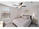 Cozy bedroom with ceiling fan, neutral carpet, and a large window for natural light at 9334 Lemon Drop Loop, Sun City Center, FL 33573