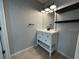 Bathroom with a white vanity, floating shelves, updated lighting, and tiled flooring for a modern look at 10101 Paddock Oaks Dr, Riverview, FL 33569