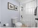 Bright bathroom featuring a shower/tub combo, white ruffled curtains, and tiled wall at 10101 Paddock Oaks Dr, Riverview, FL 33569
