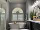 Elegant bathroom with a freestanding tub, modern lighting, and neutral tones at 10101 Paddock Oaks Dr, Riverview, FL 33569