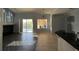 Open-concept living room with view into kitchen, tile floors, and large glass doors to the pool area at 10101 Paddock Oaks Dr, Riverview, FL 33569