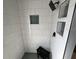 Stylish shower with white subway tile walls, black mosaic floor, and built-in niches for toiletries at 10101 Paddock Oaks Dr, Riverview, FL 33569