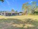 Expansive backyard with a screened-in pool and mature trees at 12301 Folger St, Spring Hill, FL 34609