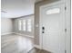 Welcoming foyer with white front door, wood-look flooring, and ample natural light at 12301 Folger St, Spring Hill, FL 34609