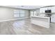 Open-concept kitchen and living area with modern gray flooring and white island at 12301 Folger St, Spring Hill, FL 34609
