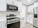 Updated kitchen boasts stainless steel appliances, white cabinets, and quartz countertops at 12301 Folger St, Spring Hill, FL 34609