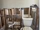Bathroom shows toilet, exposed pipes, and studs ready for renovation at 15816 2Nd St E, Redington Beach, FL 33708
