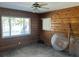 Cozy bedroom featuring wood paneled walls, concrete floors and two windows at 15816 2Nd St E, Redington Beach, FL 33708