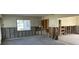 Open-concept living room features large window, concrete floors, and exposed wall framing at 15816 2Nd St E, Redington Beach, FL 33708