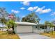 Light blue home with a white garage door and landscaping at 1816 Woodridge Dr, Clearwater, FL 33756