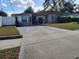 Single-story home with driveway, fenced yard, and manicured lawn at 1825 Heather Ave, Tampa, FL 33612