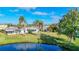 Ranch-style home with water view, lush landscaping, and palm trees at 2460 Terry Ln, Sarasota, FL 34231