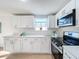 Modern kitchen with white cabinets, stainless steel appliances, and quartz countertops at 2460 Terry Ln, Sarasota, FL 34231