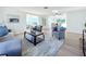 Light filled living room with hardwood floors, ample seating, and sunroom access at 2460 Terry Ln, Sarasota, FL 34231